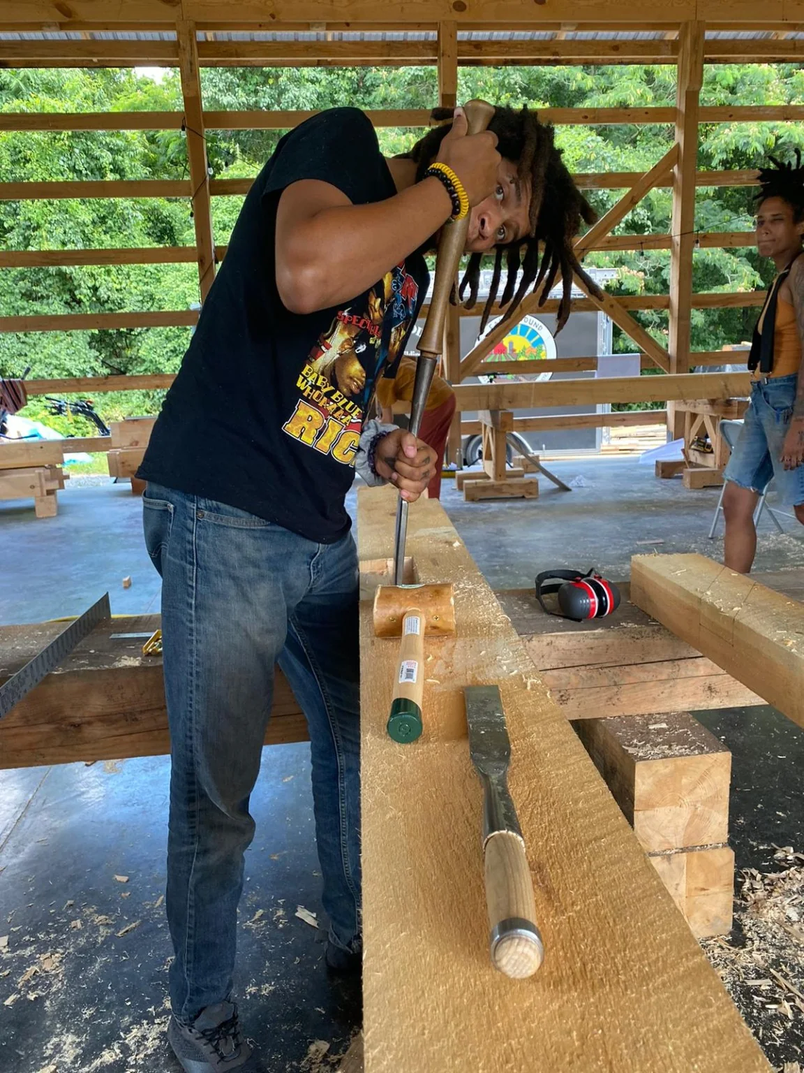 Dom chiseling traditional timber-frame joinery during a 2021 pavilion class in Upper Marlboro Maryland