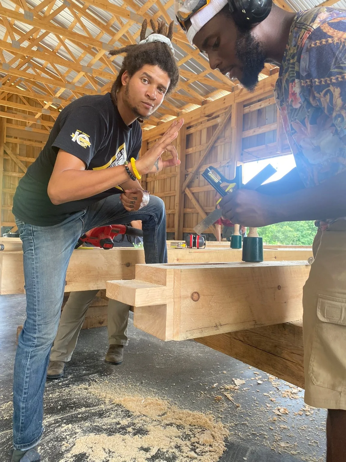 Dom working at a timber-framing bench during pavilion training.