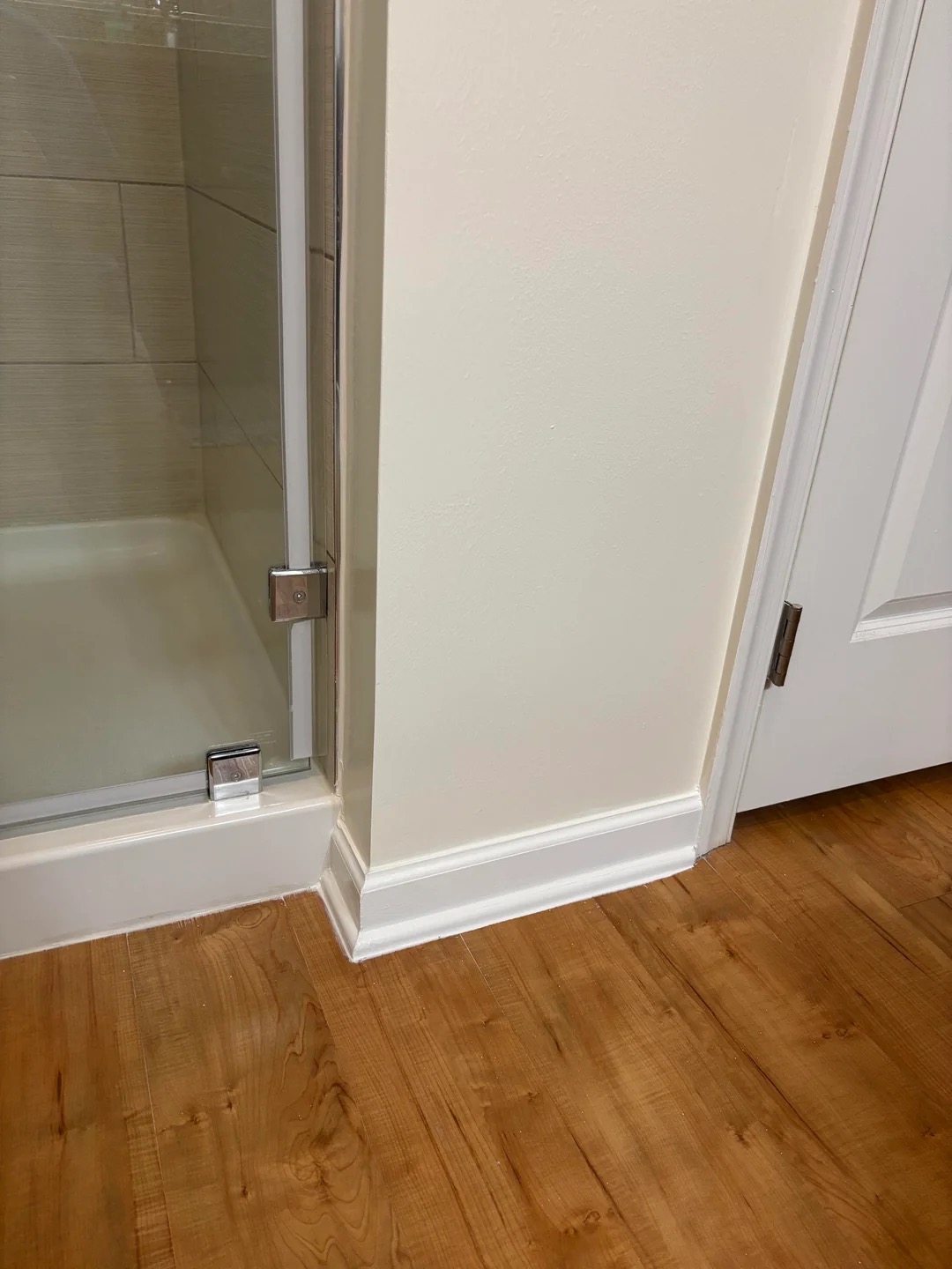 Finished drywall repair with a clean corner where a shower meets a doorway.