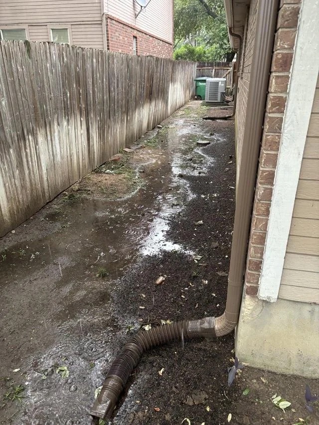 The side-yard channel after regrading, shaped to carry water away from the foundation.